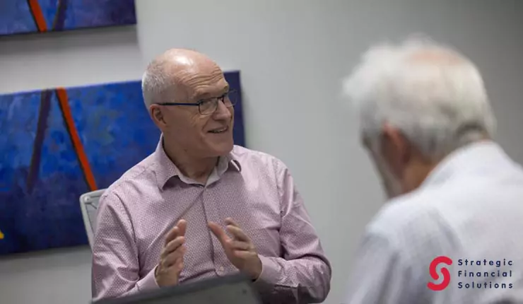 choosing-the-right-financial-advisor Financial adviser speaking with an older client during an in-person consultation.